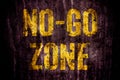 Ã¢â¬ÅNo-Go ZoneÃ¢â¬Â warning sign in yellow letters painted over dark grungy concrete wall texture background. Royalty Free Stock Photo